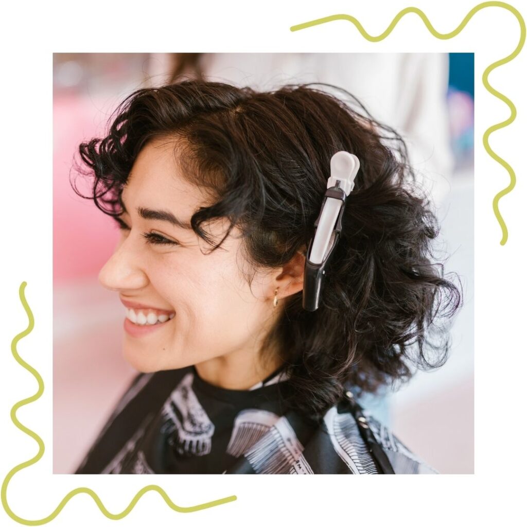 A woman smiling after getting her hair done